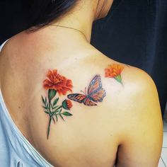 a woman with a butterfly tattoo on her back shoulder and flowers in the foreground