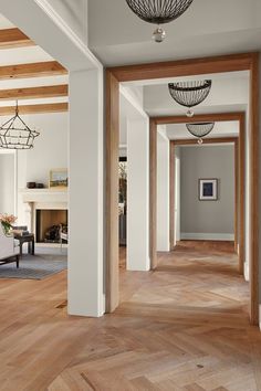 an empty hallway with wood floors and white walls