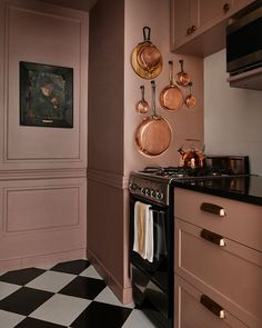 a black and white checkered floor in a kitchen with pots and pans hanging on the wall