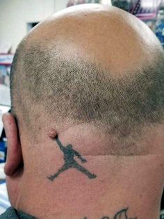 the back of a man's head with a tattoo on his forehead and an air jordan