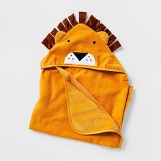 a yellow lion hooded blanket on top of a white surface