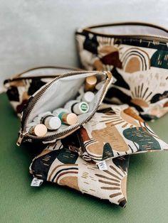 two purses sitting on top of a green table next to each other with buttons in them