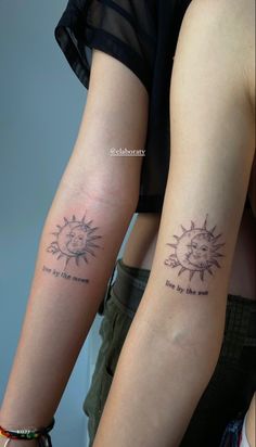 two people with sun tattoos on their arms, one is holding the other's arm