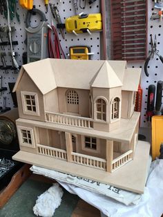 a wooden model of a house sitting on top of a workbench