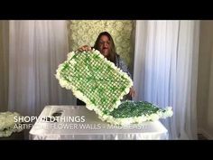 a woman is holding up a large cake made to look like a netted flower wall