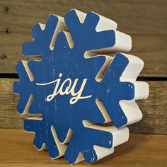 a blue and white snowflake with the word jay written on it