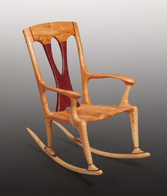 a wooden rocking chair with red paint on the seat and back, in front of a gray background