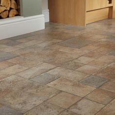 a kitchen floor with wood stacked on top of it