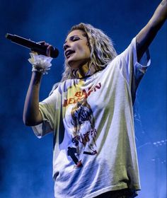 a woman holding a microphone up in the air