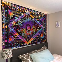 a large tapestry hanging on the wall above a bed