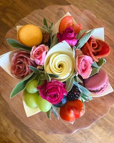 a vase filled with lots of different types of flowers on top of a wooden table