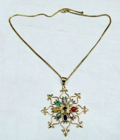 18 k solid gold, and nine different gemstones navratna pendant with chain necklace. total weight-17.200 grams, size of pendant-5.5/5 cm, length of chain-16 inches ( we can adjust to any length), name of all gems are as follows-center one is ruby than red coral, night garnet, blue sapphire, cats eye, yellow sapphire, emerald, diamond, and pearl. Antique Gold Necklace With Multi-stones, Antique Gold Multi-stone Necklace, Antique Multi-stone Pendant Necklace, Temple Jewelry Style Multi-stone Pendant Necklace, Traditional Yellow Gold Multi-stone Necklace, Antique Temple Necklace With 17 Jewels As Gift, Gold Kundan Necklace With Gemstones For Spiritual Use, Spiritual Gold Kundan Necklace With Gemstones, Gold Kundan Necklace With Gemstone For Spiritual Occasions