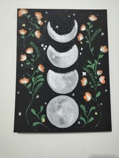 a painting with three phases of the moon and flowers painted on it's sides