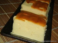 two slices of cake sitting on top of a black plate next to a brown and white mat