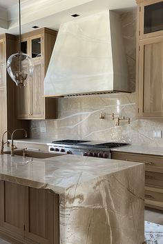 a kitchen with marble counter tops and wooden cabinets, an island in the foreground