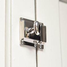 a door handle on the side of a white door with metal latches and knobs