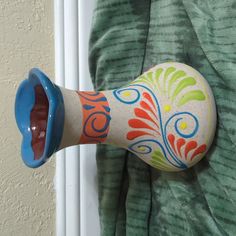 a toy blow dryer sitting on top of a green blanket next to a wall