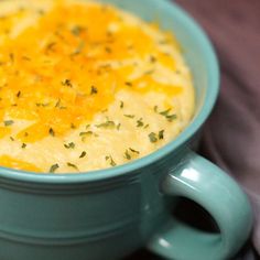 a blue bowl filled with soup and topped with cheese