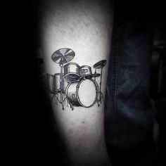 a man's arm with a drum and drums tattoo on it, in black and white