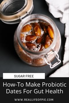 a jar filled with dates sitting on top of a table next to a cup of coffee