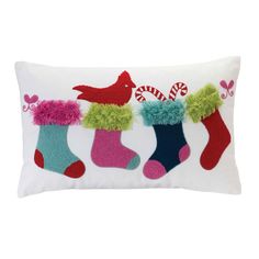 a white pillow with christmas stockings and candy canes on the front, along with a red bird