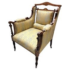 an old fashioned chair with yellow and blue upholstered fabric on the armrests