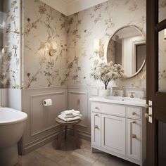 a white bathroom with floral wallpaper and gold accents on the walls, along with a pedestal sink