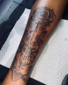 a person with a tattoo on their arm that reads, faith is loved and flowers are in the background