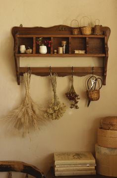 an old wooden shelf with several items hanging from it's sides and two baskets on the wall