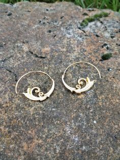 A pair of geometric earrings made of metal alloy. Modern Swirl Earrings For Gift, Elegant Spiral Metal Earrings, Gold Swirl Earrings For Pierced Ears, Swirl Earrings For Pierced Ears, Bohemian Gold Swirl Jewelry, Elegant Spiral Brass Hoop Earrings, Spiral Brass Pierced Earrings, Spiral Metal Earrings, Spiral Brass Jewelry