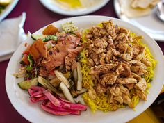 a white plate topped with meat and veggies on top of a purple table