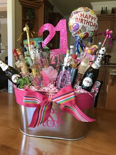 a birthday gift in a bucket with balloons, confetti, and other items