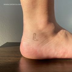 a small foot with a tiny tattoo on the top of it's left leg