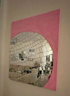 a mirror that is on the side of a wall with a pink border around it