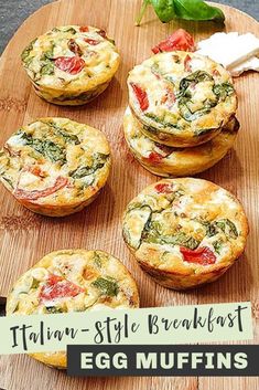 four small muffins with spinach and tomatoes in them on a cutting board