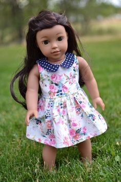 a doll is standing in the grass wearing a dress