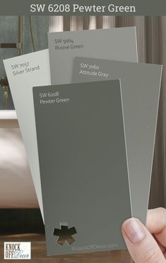 a person holding three different shades of paint in their hand with the text sw 628 pewter green