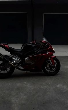 a red motorcycle parked in front of a building