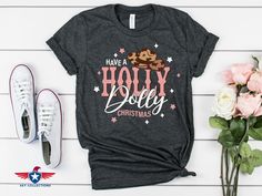 "Have a Holly Dolly Christmas Shirt, Dolly Parton Christmas T-Shirt, Christmas Gift For Women, Dolly Christmas Shirt, Holly Dolly Shirt ----------- How to Order Your Custom Design T-shirt ---------- * Choose your t-shirt color * Choose your size * Choose your design&text color * PLEASE make sure all your order's steps Example: Text&Design Color:Black ---------- Product ---------- * 4.2 oz., 100% airlume combed and ringspun cotton, 32 singles * 32 singles Athletic Heather and Black Heather are 90 Dolly Parton Christmas, Dolly Parton T Shirt, Dolly Christmas, Dolly Shirt, Holly Dolly, Christmas Gift For Women, Design Text, Message Box, Dolly Parton