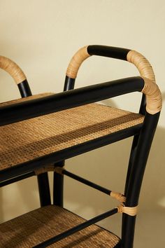 two black chairs with wicker seats on them