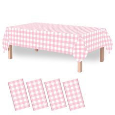 a pink and white checkered table cloth next to four pieces of cut out paper