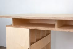 a wooden desk with two open shelves on the top and one closed shelf below it