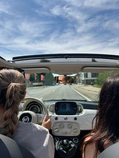 two women in the back seat of a car driving down a road