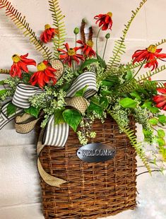 a wicker basket with red flowers and greenery on the wall next to a sign that says welcome