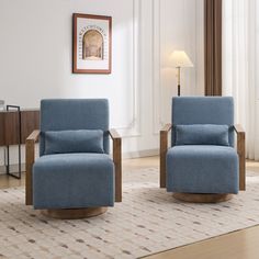 two blue chairs sitting in a living room next to each other on top of a rug