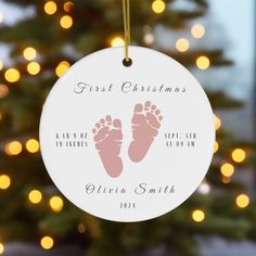 a personalized ornament for a baby's first christmas with footprints on it