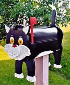 a black cat mailbox sitting in the grass