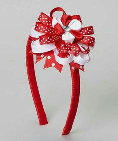 a red headband with white polka dots and a large bow on the side that is attached to it