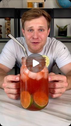 a man holding a mason jar filled with liquid