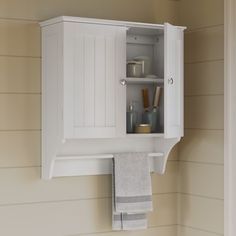 a white cabinet with towels hanging from it